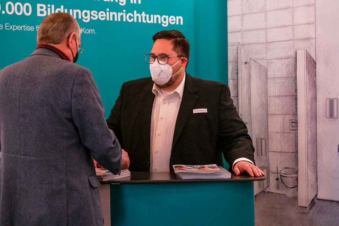 AIR-WOLF Messe Impression Schulbau Frankfurt 2022 02 AIR-WOLF Messestand auf der Schulbau Messe Frankfurt 2022. Herr Fröhlich berät einen Interessenten zu unserem Armhebelspender.